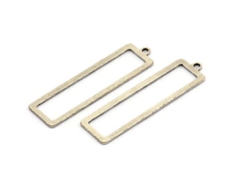 Puede incluir: Dos colgantes rectangulares de metal de color dorado con un bucle en la parte superior para colgar.