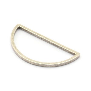 May include: A silver half-circle ring with a smooth, slightly textured finish.