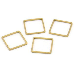 Puede incluir: Cuatro anillos metálicos cuadrados de color dorado. Los anillos están abiertos y tienen un acabado liso.