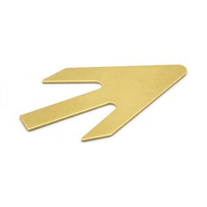 May include: A gold-colored metal arrow-shaped tool with a split tip.