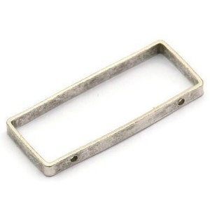 May include: Silver-toned rectangular metal frame with two holes. The frame has a slightly distressed finish.