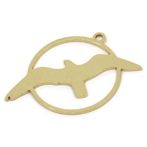 May include: Gold metal charm featuring a cutout silhouette of a seagull flying inside a circle.