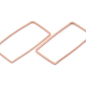 May include: A pair of rose gold rectangular hoop earrings. The earrings are made of a thin wire and have a simple, modern design.