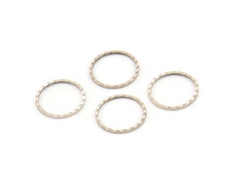 May include: Four silver-toned metal rings with a textured, ridged design. The rings are all the same size and are arranged in a circle.
