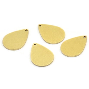 Puede incluir: Cuatro abalorios de metal de color dorado en forma de lágrima con un agujero en la parte superior para colgar.