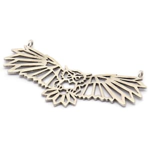 May include: A silver pendant in the shape of an owl with its wings spread out. The owl is made of geometric shapes and has a detailed design.