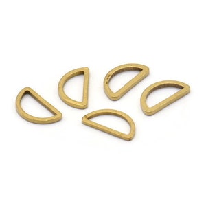 May include: Five gold-colored metal half-circle rings with a gap in the middle. The rings are arranged in a semi-circle pattern.