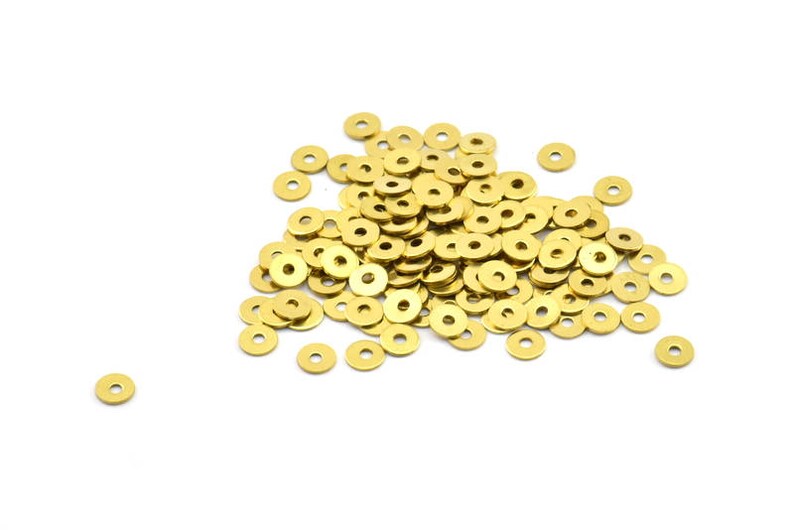 May include: A large pile of gold-colored metal washers. The washers are round with a hole in the center.