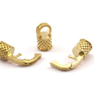May include: Three gold-toned metal clasps with a textured surface. Each clasp has a hook and a loop for attaching to a chain or cord.