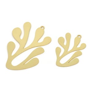May include: Two gold-coloured metal charms shaped like stylised leaves. The larger charm is about 5 cm tall and the smaller charm is about 2.5 cm tall.