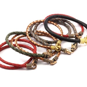 K&ouml;nnte beinhalten: Ein Set aus sechs Lederarmb&auml;ndern mit verschiedenen geflochtenen Lederfarben und Metall-Wolfs-Kopf-Verschl&uuml;ssen.