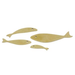 May include: Four brass fish cutouts of varying sizes are arranged on a white background. Each fish has a simple, streamlined shape with a small eye hole. The fish range in size from small to medium, with a smooth, metallic finish.