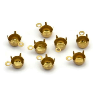 May include: Ten gold-colored metal cup settings with a loop on top. The cups are designed to hold a gemstone or bead.
