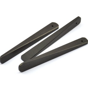 May include: Three black wooden tapered sticks with a small hole at the top of each stick.