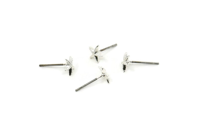 May include: Four silver star-shaped stud earrings with a post and butterfly backing.
