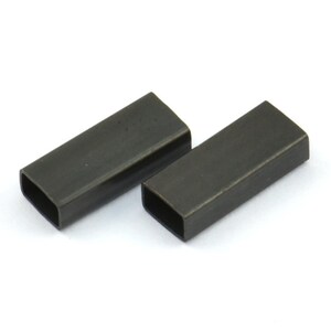 May include: Two black metal rectangular-shaped cable clamps. The clamps are made of metal and have a smooth, matte finish.