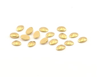 May include: A collection of 15 gold-colored oval-shaped metal embellishments. The embellishments have a slightly domed top and a flat bottom.