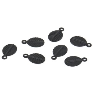 May include: Eight black metal leaf charms with a loop for attaching to jewellery or other crafts.