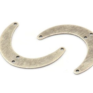 May include: Two antique silver-toned metal crescent moon shapes with holes for attaching jewelry findings.