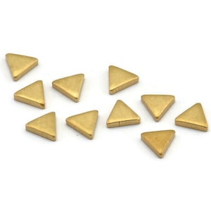 Peut inclure: Un groupe de 12 petits embellissements métalliques en forme de triangle de couleur dorée.