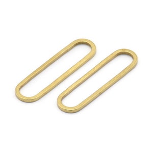May include: Two gold oval-shaped metal rings. The rings are smooth and have a slightly rounded edge.