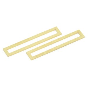 Könnte beinhalten: Zwei rechteckige Ohrringe in Goldfarbe mit einem hohlen Zentrum.