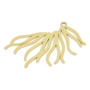 May include: Gold-toned metal pendant featuring a decorative design that resembles a stylised branch with multiple curved lines.