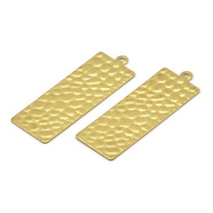May include: Two gold-toned metal rectangular pendant charms with a hammered texture. The charms have a hole at the top for attaching to a chain or cord.