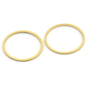 Puede incluir: Dos anillos de metal de color dorado, cada uno con una superficie lisa y redondeada.