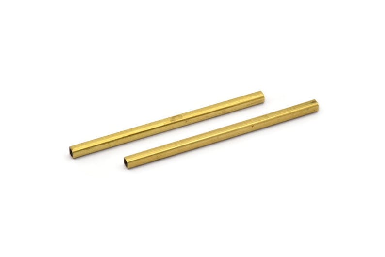 May include: Two gold-coloured metal rods, each approximately 15 cm long, with a square cross-section.
