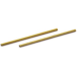 May include: Two gold-coloured metal tubes, one slightly longer than the other, are lying on a white surface.