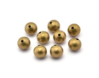 May include: Ten gold-colored round beads with a hole in the center. The beads are scattered on a white surface.