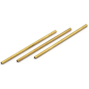 May include: Three brass tubes of varying lengths, arranged diagonally on a white background.
