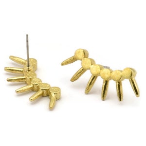 May include: A pair of gold-toned earrings with a geometric design. Each earring features a curved row of small, round beads with five pointed spikes extending from the bottom.