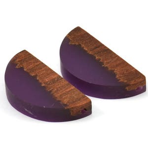 May include: Two half-circle resin and wood pendant charms. The resin is a deep purple colour and the wood is a rich brown. The charms have a hole drilled through the top for hanging.