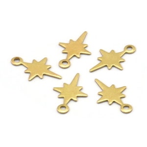 May include: Five gold-toned metal starburst charms with a loop at the top. Each charm has a pointed star shape with a textured surface.