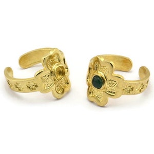May include: Two gold toe rings with a flower design. Each ring has a green gemstone in the center of the flower.