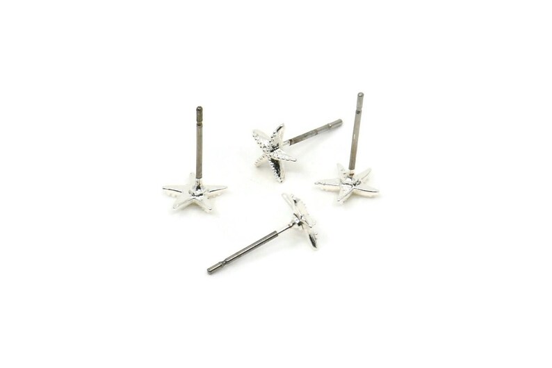 May include: Four silver starfish stud earrings with a post and butterfly backing.