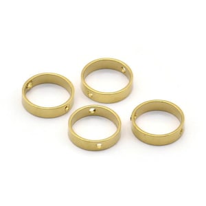 May include: Four gold-colored metal rings with two small holes in each ring.