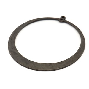 May include: A dark brown metal ring with a small loop on the top. The ring is smooth and has a slightly rounded shape.