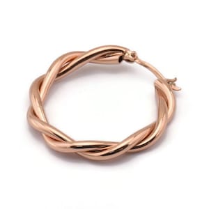 Könnte beinhalten: Ohrringe aus Roségold mit einem gedrehten Design.