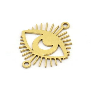 Puede incluir: Encanto de metal dorado con un diseño de ojo detallado y un patrón de rayos de sol. El encanto tiene dos anillos de salto para sujetarlo a joyas.
