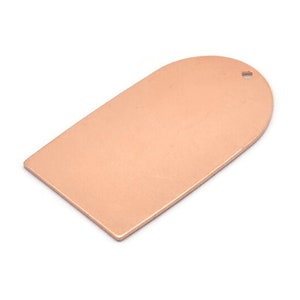 May include: A blank, rose gold-coloured metal tag with a rounded top and a hole punched in the top. The tag is approximately 5 cm long and 2.5 cm wide.
