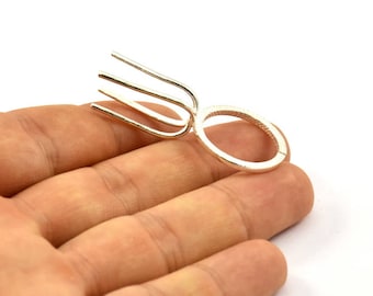 May include: A silver ring with a unique design featuring a three-pronged fork-like element attached to a circular band.