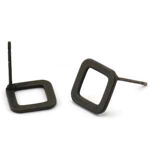 Könnte beinhalten: Ein Paar schwarze quadratische Ohrstecker mit einem schlichten, minimalistischen Design.