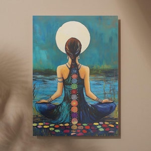 May include: A painting of a woman sitting in a lotus position with her back to the viewer. She has a long braid with colorful circles down her spine, representing the seven chakras. The background is a blue and green landscape with a full moon.