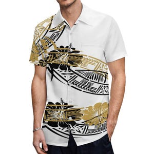 Puede incluir: Una camisa blanca de manga corta con botones con un estampado de inspiraci&oacute;n polinesia en negro y dorado. El estampado presenta un patr&oacute;n repetitivo de formas geom&eacute;tricas y dise&ntilde;os florales.