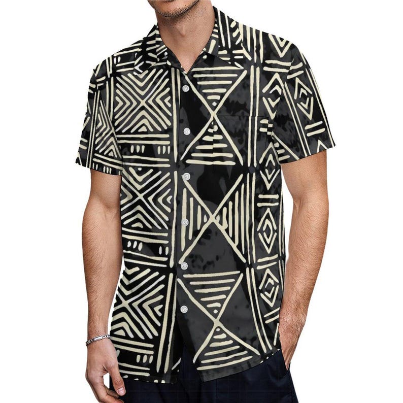 Puede incluir: Una camisa de botones de manga corta de color negro y blanco con un patr&oacute;n geom&eacute;trico. El patr&oacute;n est&aacute; formado por l&iacute;neas y formas blancas sobre un fondo negro.