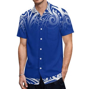 Puede incluir: Una camisa azul de manga corta con botones y un estampado tribal blanco. La camisa tiene un bolsillo en el lado izquierdo.