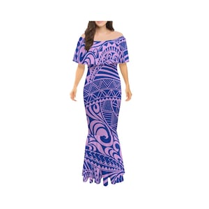 Op de afbeelding: Een lange, roze en blauwe jurk met een off-shoulder halslijn en een mermaid rok. De jurk heeft een geometrisch patroon geïnspireerd op Polynesische tatoeagekunst.